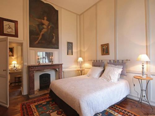 Le GraisGîte Le Grais, 3 pièces, 4 personnes - FR-1-497-13的一间卧室配有一张带壁炉和绘画的床。