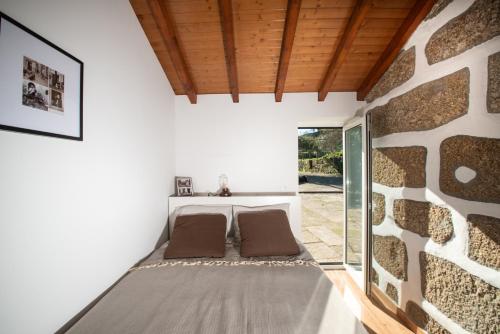 派瓦堡Family Room - Quinta do Mirante的一间设有两张床和石墙的房间