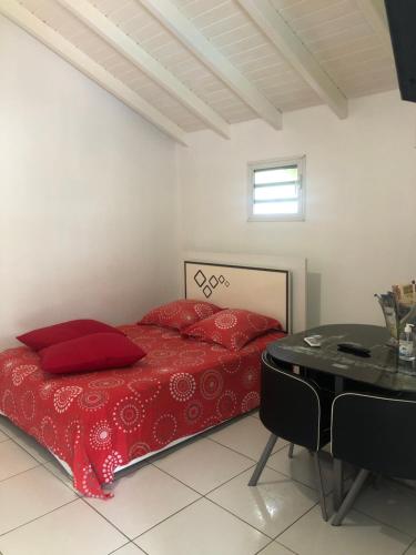 珀蒂堡Kaban‘ Malaka的一间卧室配有红色的床和一张桌子