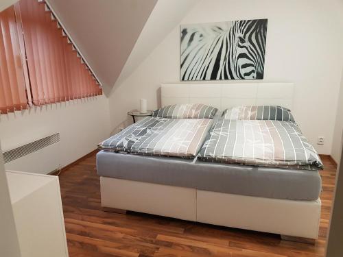 布尔诺附近斯拉夫科夫Apartmán V aleji的卧室配有一张床,墙上挂着斑马图