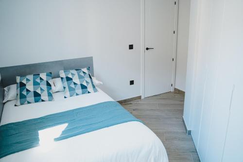 特鲁埃尔Apartamentos Turia Teruel的卧室配有白色的蓝色调床。