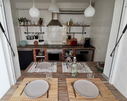 西尔韦斯Algarve house, sun, terrace, views and barbecue的厨房配有一张桌子,上面有三个白板