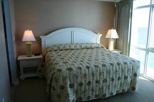 默特尔比奇Club Regency at Regency Towers的一间卧室配有一张床和两个带灯的床头柜