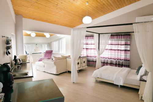 布加勒斯特Chic Studio的大型客厅配有白色家具和窗户。