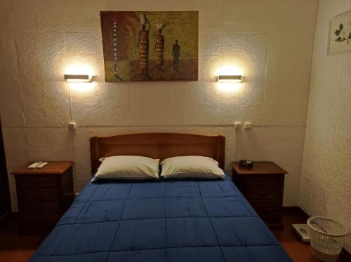蓬塔德尔加达瓦拉多斯公寓的一间卧室配有蓝色的床和2个床头柜