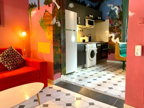 法兰西堡Le Patio Foyalais的一间带红色沙发的客厅和一间厨房