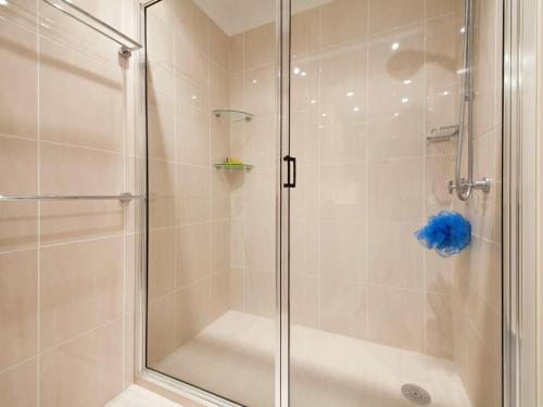 尼尔森湾马格努斯街6/58-60号卡米拉罗公寓的浴室里设有玻璃门淋浴