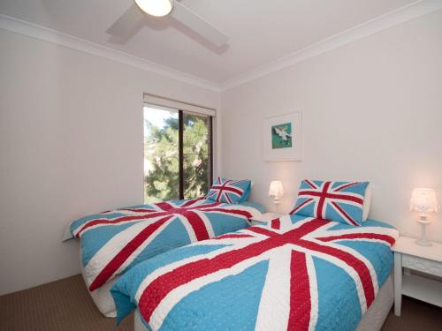 尼尔森湾Bay Parklands Unit 35 2 Gowrie Avenue的一间卧室配有两张红色白色和蓝色的床