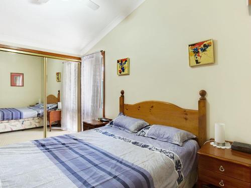 尼尔森湾马卡达米亚区政府路8号2号别墅的一间卧室配有一张大床和镜子