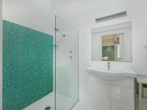 莫里莫科Tallwoods Beach House的一间带水槽和玻璃淋浴的浴室