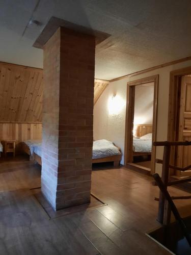 Sabile阿特玛塔斯度假屋的一间设有砖砌壁炉的房间和一间卧室