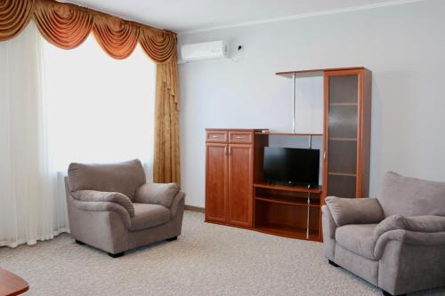 戈卢比茨卡亚Mini-Hotel Morskoi rif的客厅配有2把椅子和平面电视