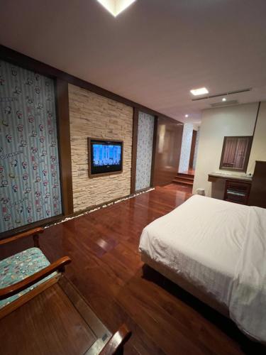 花莲市采盈精品休闲旅馆的一间卧室配有一张床,墙上配有电视