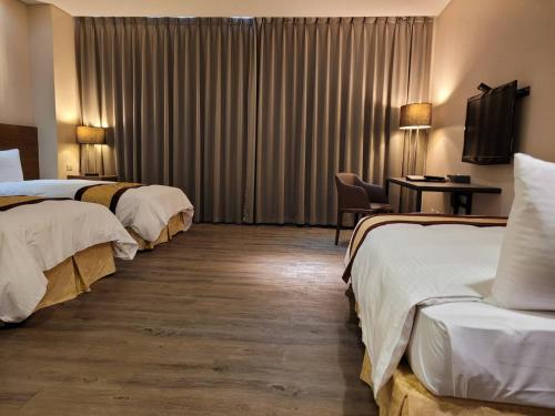 朴子山海大饭店的酒店客房设有三张床和一张桌子及椅子