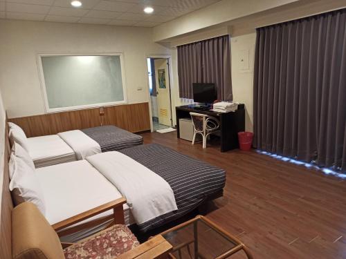 Wenquan九族飯店 臺東縣旅館004號的一间医院间,配有两张床和一张书桌