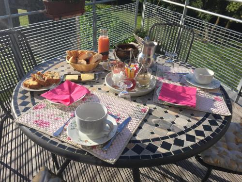 奥尔西讷Coté Puy-De dôme的阳台上的桌子上摆放着食物和饮料