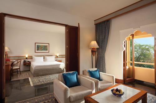 斋浦尔泰鼎浦尔酒店的酒店客房设有一间带一张床和椅子的卧室