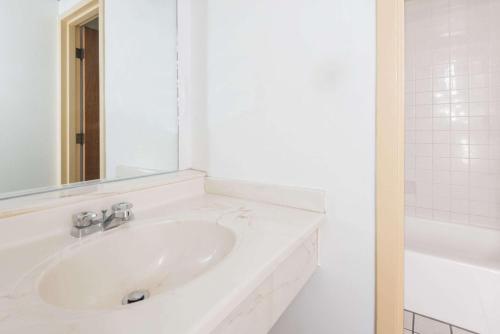 拉勒米Super 8 by Wyndham Laramie的白色的浴室设有水槽和镜子