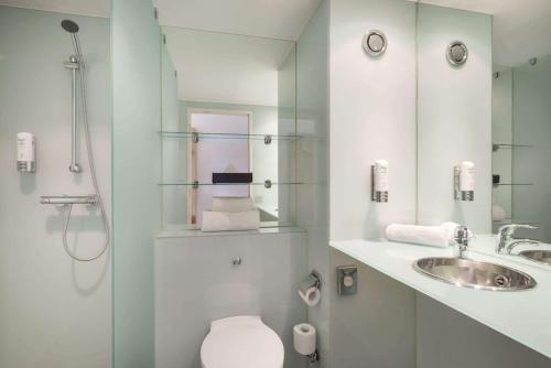 贝尔法斯特Ramada by Wyndham Belfast的浴室配有卫生间、盥洗盆和淋浴。