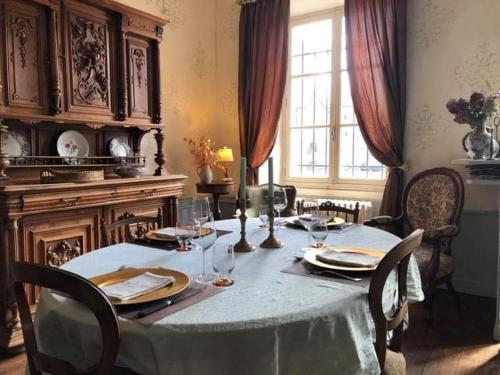 BoussacAncienne Perception的用餐室配有带盘子和酒杯的桌子