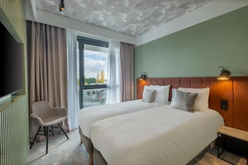 利莫内KYRIAD LYON OUEST Limonest的酒店客房设有两张床和窗户。