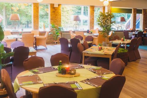 德吕特Hotel de Grote Zwaan的一间在房间内配有桌椅的餐厅