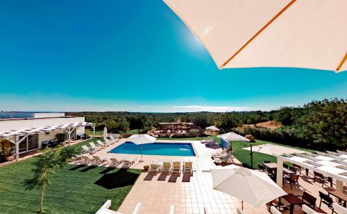 塔维拉布兰卡住宿加早餐旅馆的度假村的游泳池配有椅子和遮阳伞