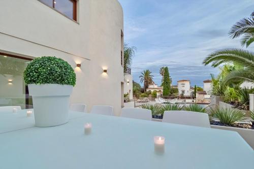 艾姆布里亚布拉瓦Villa N15 en plein cœur de la Marina, proche de Rosas, Costa Brava的白色的桌椅,享有房子的景色
