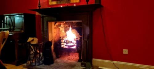 桑希尔巴克卢和昆斯伯里阿姆斯力推酒店的红色房间壁炉里的火