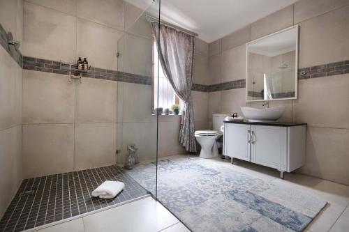 罗伯森Adderley House Guest Accommodation的带淋浴、盥洗盆和卫生间的浴室