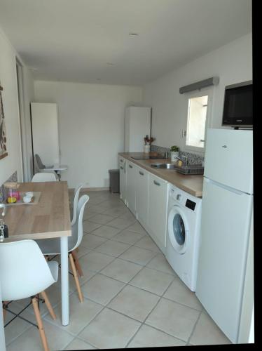 GattièresF1 avec un espace jardin的厨房配有桌子和洗衣机。