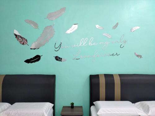 金宝U&I HOMESTAY KAMPAR的卧室配有两张挂在墙上的羽毛床。