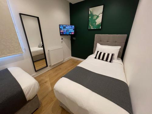 曼彻斯特曼彻斯特码头公寓的一间卧室配有两张床、镜子和电视