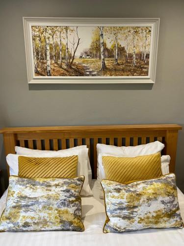 Rufford拉福德阿姆斯酒店的挂在床上的画作和两个枕头