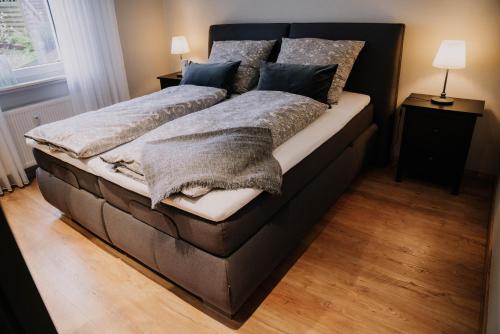 赫尔博恩Waldblick Herborn的卧室配有一张带毯子和枕头的大床