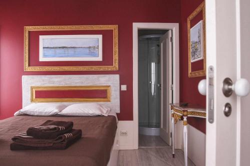 塞沙尔Legendary Bay Apartamento Temático的一间卧室设有红色的墙壁和一张带毛巾的床