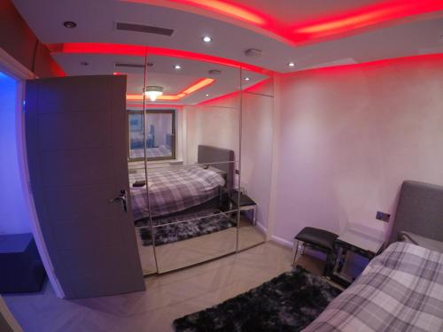 伦敦Perfect Central London Base的一间设有两张床的客房,天花板上设有红灯。