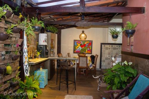 里约达欧特拉斯Jardim Encantado da Lagoa的厨房以及带桌子和一些植物的用餐室