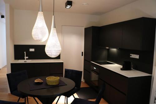 格里斯基兴Das Stadthouse的厨房配有黑色橱柜和桌椅