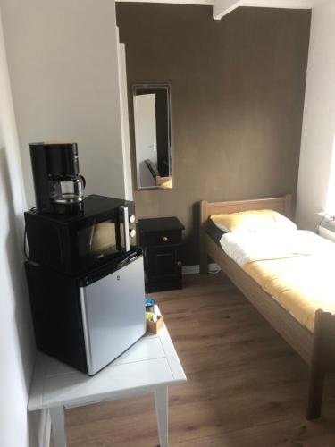 恩斯赫德City Center Enschede Homestay的一个小房间,配有电视和一张床