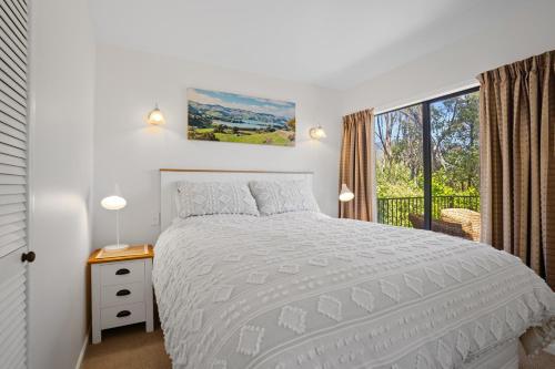 阿卡罗阿Woodside - Akaroa Holiday Cottage的白色的卧室设有床和窗户