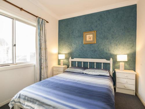 安特兰斯Sea Spray Apartments Unit 4的一间卧室配有一张蓝色墙壁的床