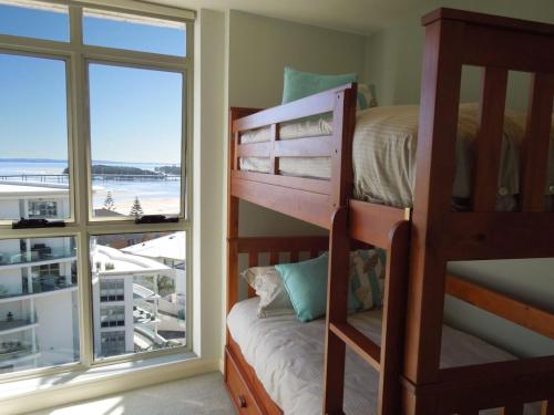 安特兰斯Ocean Views Sundrift Unit 26的一间卧室设有双层床和大窗户
