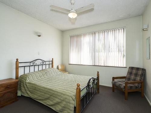 安特兰斯The Sands Unit 5的卧室配有床、椅子和窗户。