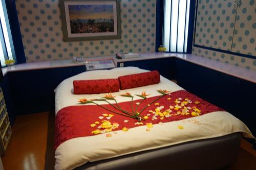 岸和田市沙阿奈恩酒店（仅限成人）的一间卧室,床上放着鲜花