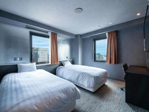 滨松EN HOTEL Hamamatsu的酒店客房带两张床和两个窗户