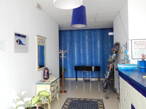 科尼尔-德拉弗龙特拉Apartahotel Playa Conil的客厅配有蓝色窗帘和钢琴