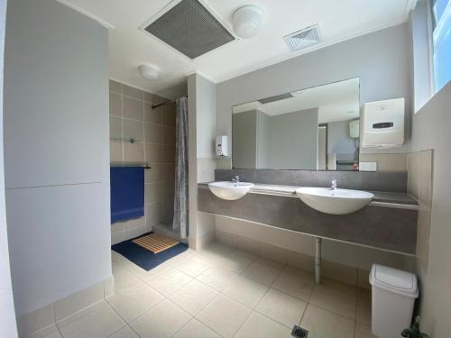 黄金海岸Homely Inn Hostel的浴室设有2个水槽和镜子