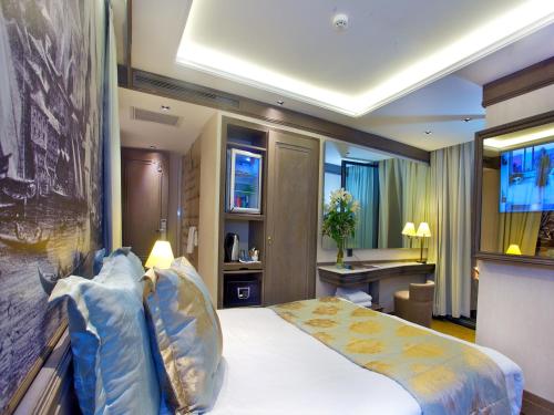 伊斯坦布尔Pierre Loti Hotel Old City- Special Category的配有一张床和一张书桌的酒店客房