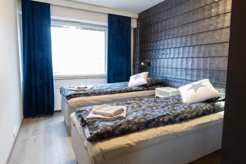 罗瓦涅米Apartment Rovakatu B12的配有蓝色窗帘和窗户的客房内的两张床